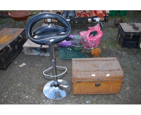 A small metal trunk and a rotating bar stool.