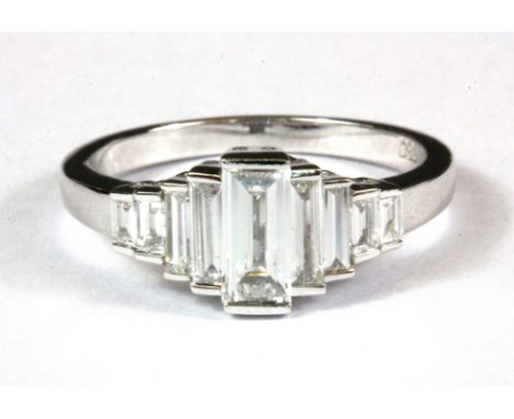 An 18ct white gold (stamped 750) baguette cut diamond set graduated ring, approx. 0.85ct (N).