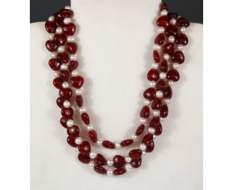 An unusual necklace of cultured pearls and heart shaped red jade beads on a porcelain rose clasp, longest strand 46cm.