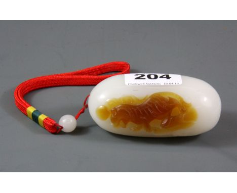 A Chinese carved white and russet jade pebble, L. 9cm. (Prov. Samy collection).