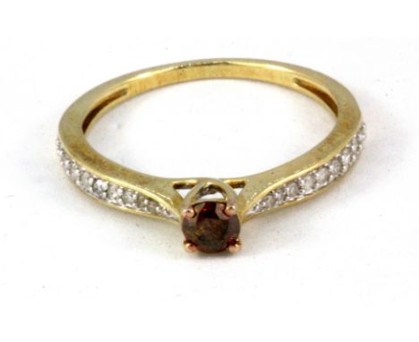 A 9ct yellow gold solitaire ring set with a brilliant cut cinnamon diamond and diamond set shoulders, (Q).