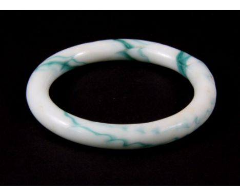 A Chinese glass bangle imitating jade, probably 19th Century, internal Dia. 5.8cm. (Prov. Samy collection).