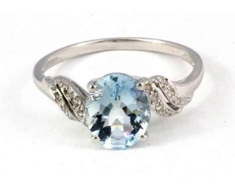A 9ct white gold aquamarine set ring with diamond set shoulders, (Q).