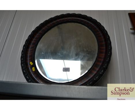An oval and bevel edged wall mirror