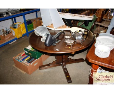 A circular extending dinning table with a set of six stick and wheel back chairs to include two carvers