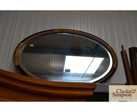 An oval and bevel edged wall mirror