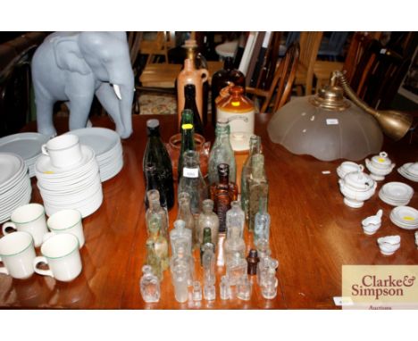 A quantity of vintage glass bottles, together with a quantity of vintage stoneware bottles etc.
