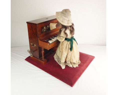 19th century musical automaton girl playing piano. Underskirt of the girls dress is breaking apart due to age, 2 of the piano