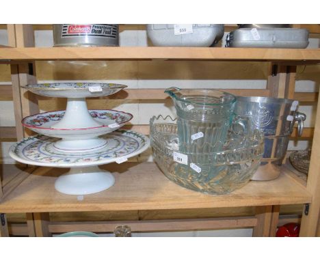 Three ceramic cake stands together with an aluminium ice bucket, glass jug and bowl