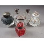 A pair of silver topped clear glass scent bottles, a white metal topped dressing table jar, a silver