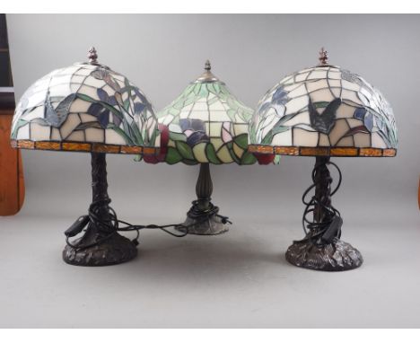 A pair of table lamps with Tiffany style stained glass shades, decorated butterflies and flowers, 16" high, a similar larger 