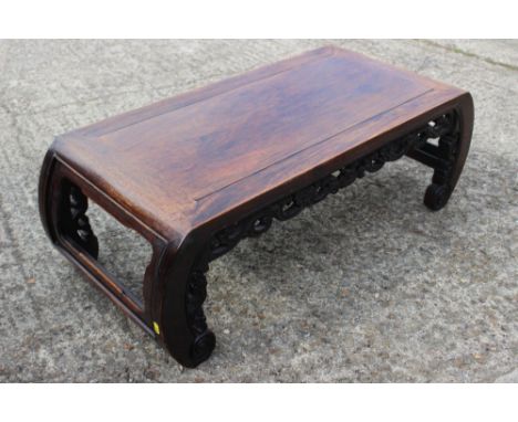 A Chinese carved hardwood low table, on scroll end supports, 37" long x 16 1/2" deep x 12 1/2" high Condition: Surface scratc