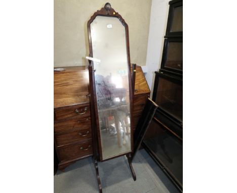 A mahogany cheval mirror with shaped arch and carved shell crest, standards topped with brass finials (one loose), plate 48" 