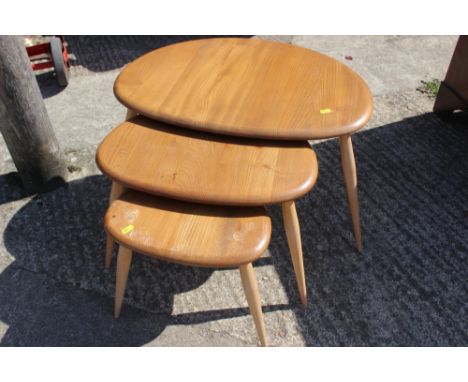 A nest of three Ercol, "Pebble" occasional tables, on splay supports, largest 24" wide Condition: Some loss to varnish on sma