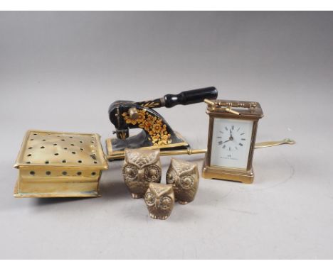 A Matthew Norman carriage clock, a brass chestnut roaster, an iron blind stamp and a graduated set of three brass owls 