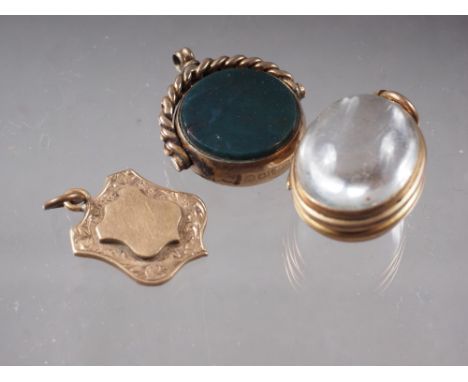 A 9ct gold fob spinner, mounted bloodstone and a compass, a yellow metal and rock crystal locket (chipped), and a 9ct gold sh