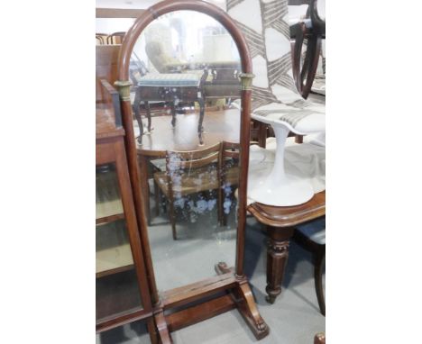 A mahogany and brass mounted Beidermeier style arch top cheval mirror, on paw feet and castored base, 23" wide x 22" dia x 64