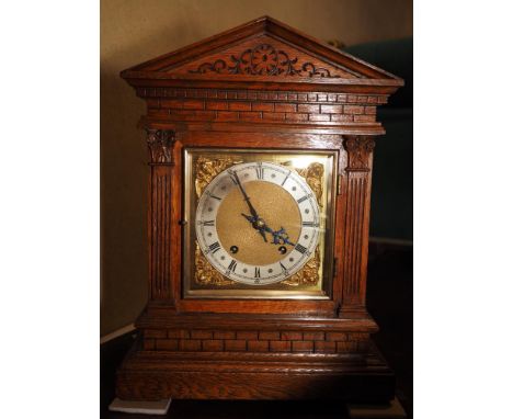 An Edwardian oak cased architectural mantel clock with brass dial and eight-day quarter striking movement, 16" high 