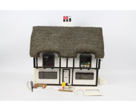 Dolls house - A home made, wooden, thatched, dolls house with electricity fittings for lights. The dolls Thatched Cottage cam