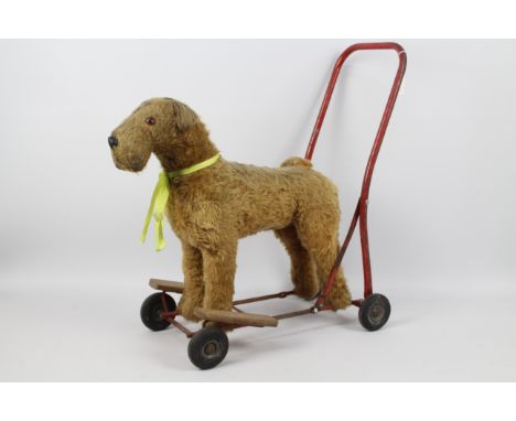 Pedigree push along / ride on dog. A vintage Pedigree Irish Terrier Push Along, on red metal frame with wheels and foot rests