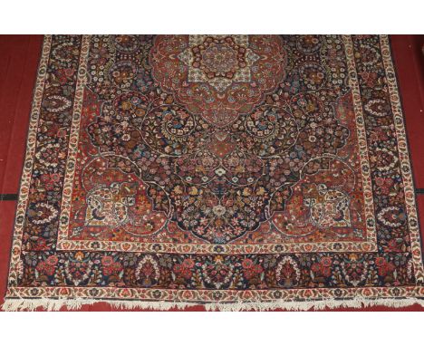 A 19th century hand woven Persian blue ground wool carpet. With a large centre medallion under a stylized floral banded borde