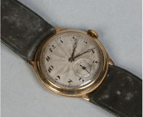 A gentleman's 9 carat gold cased manual wristwatch. With engine turned silver dial having black enamel Arabic numeral markers