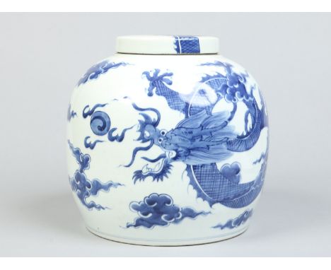 A 20th century Chinese large jar and cover. Painted in underglaze blue with a scrolling dragon chasing a flaming pearl on a g