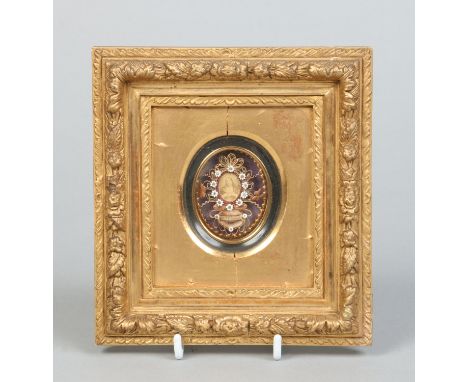 A 19th century Continental scrolled paper and beadwork reliquary in gilt frame with a portrait of Christ, 6cm x 5cm.  Conditi