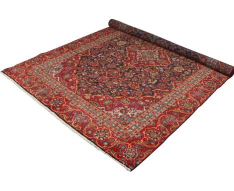 A blue and red ground Persian Kashan wool carpet with a centre medallion, 2m 13cm wide, 3m 26cm long. Condition Report. To be