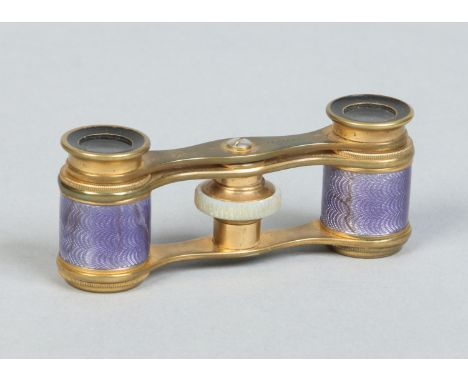 A pair of early 20th century lacquered brass opera glasses by J Duvellery, London. With purple guilloche enamel grips and mot