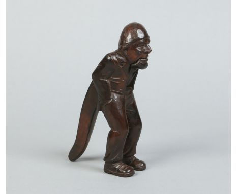 A Black Forest carved walnut nut cracker formed as a stooped elderly man with his hands in his pockets, 20cm. Condition Repor