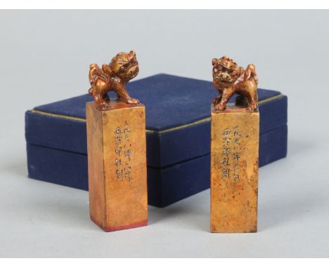 A pair of Chinese carved soapstone seals in fitted box. Each with a dog of fo terminal and with incised character marks to th