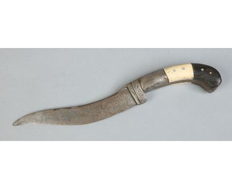 An early 20th century Eastern dagger with bone and horn scales and engraved with arabesques, 32cm. Condition Report. To be us