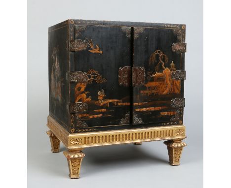 A mid 19th century Japanned table cabinet raised on a giltwood stand over toupie feet. Decorated on a black lacquer ground wi