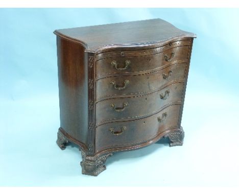 A George III-style mahogany serpentine Chest of Drawers, the shaped top with moulded edges above a slide and four long gradua