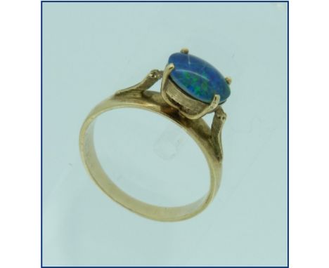 A single stone oval opal Ring, of good green/blue colour, mounted laterally, on a wide 9ct gold band, Size N½.  THIS LOT WILL