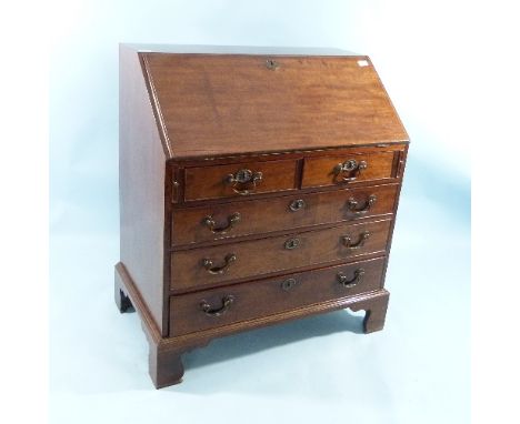 An early 19thC mahogany Bureau, the fall front enclosing a fitted interior above lopers, two short and three long graduated d