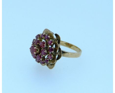 A 18ct yellow gold and ruby Ring, the front mounted with pale rubies surrounded with double leaf border, Size N. THIS LOT WIL