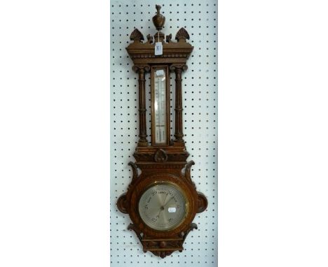 An Edwardian carved oak barometer and thermometer, of architectural form, 34in (86.5cm) high.  THIS LOT WILL BE SOLD ON SATUR