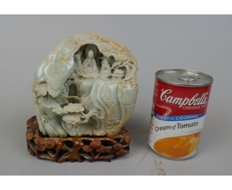 Antique carved jade boulder with scholars on a bridge in a cavernous landscape to one side and Buddhist figures in a cave to 