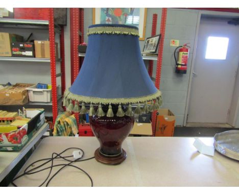 A red bulbous form table lamp with ornate tasselled shade 