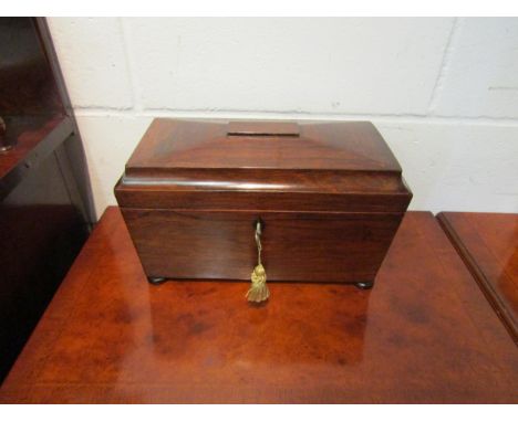 A Regency rosewood sarcophagus shaped tea caddy, with two lift-out tea boxes and central glass mixing bowl, with key 