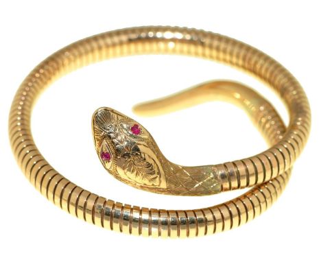 A 9ct gold serpent bracelet with ruby eyes, approximately 63mm, maker C &amp; F (incuse), Chester 1960 and marked steel sprin