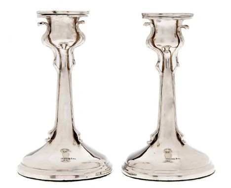 A pair of Edwardian art nouveau silver candlesticks, nozzles, 16cm h, by Walker &amp; Hall, Sheffield 1907, loaded Light wear