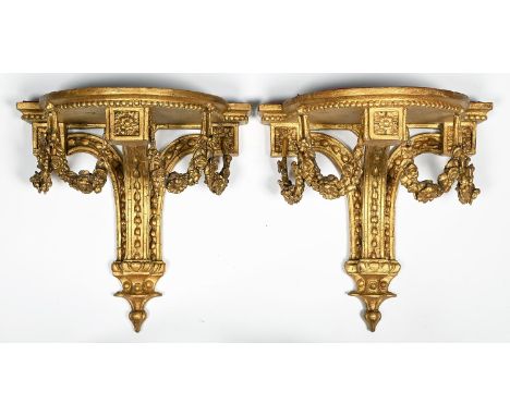 A pair of giltwood and composition wall brackets, c1900, in Louis XVI style, the breakarched shelf on three upswept supports 