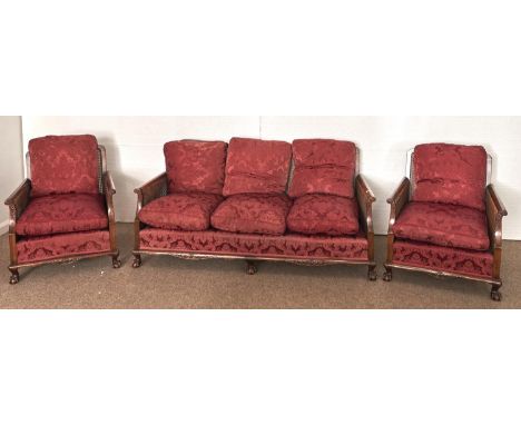 A walnut and caned bergere suite, mid 19th c, of three seat sofa and pair of armchairs, with leaf carved crest rail, cushions