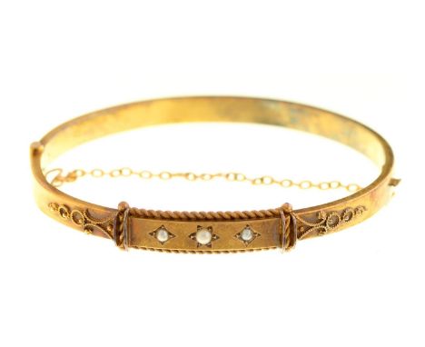 An Edwardian gold bangle, gipsy set with three split pearls, 61mm, unmarked, 9.4g, cased Slightly dented from wear