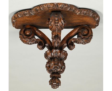 A carved walnut wall bracket, 19th/early 20th c,&nbsp;&nbsp;with oak shelf, of three recurved and beaded leaves with flower p