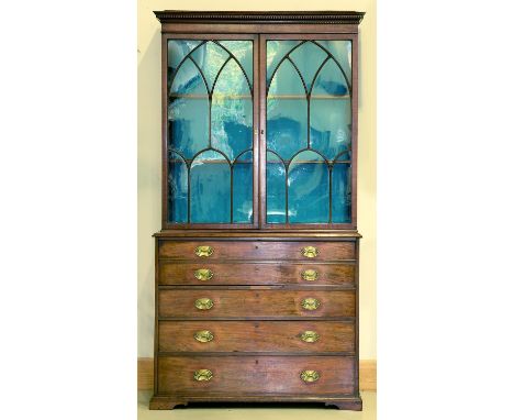 A George III mahogany secretaire bookcase, c1790, with dentil moulded flared cornice above a shallow frieze, the pair of glaz