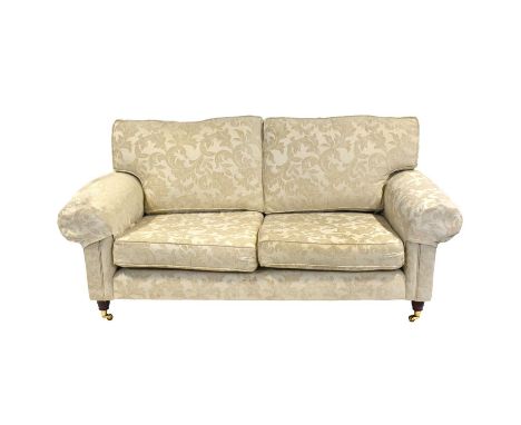 Laura Ashley two-seater settee, patterned cream upholstery, turned legs on brass casters, length approximately 193cm, height 